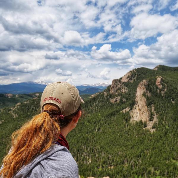 Person looking out at the mountains during a hike