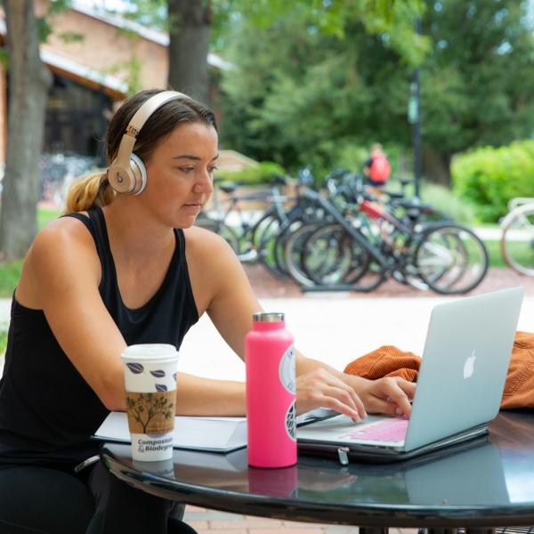Student studying on laptop outside