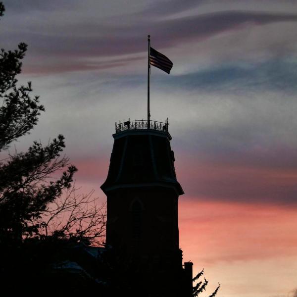 Silhouette of Old Main with sunset in background