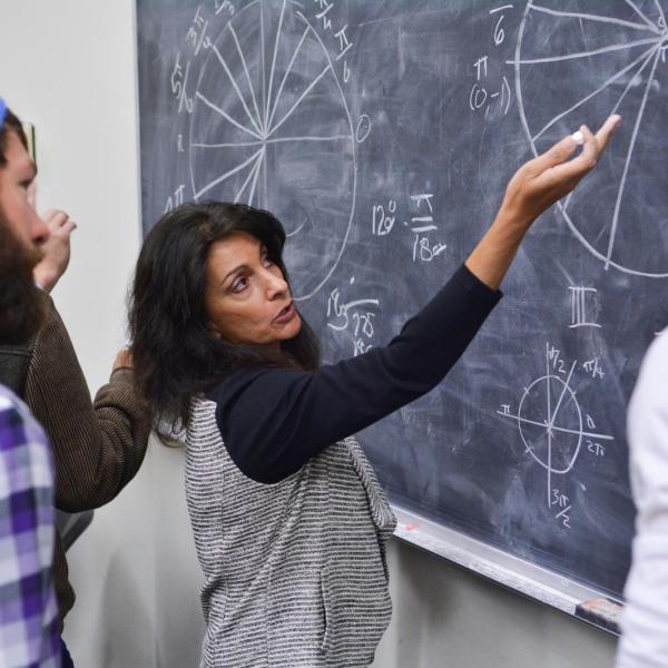 Teacher writing on a blackboard in the classroom