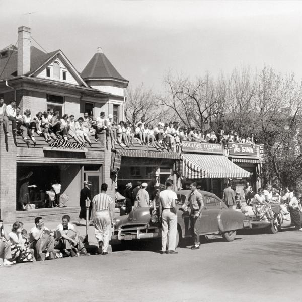 Historic image of students gathering around The Sink and sitting on the rooftop, likely for a Greek life event