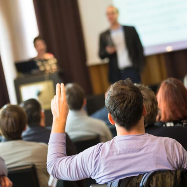 Man raises hand in town hall event