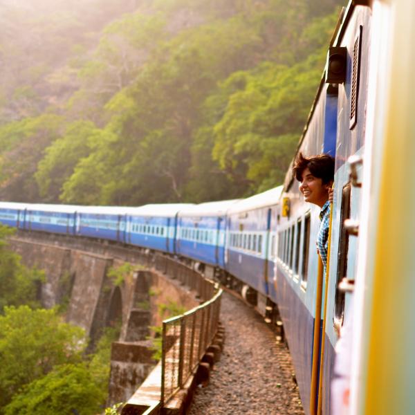 Smiling man sticks head out of train window