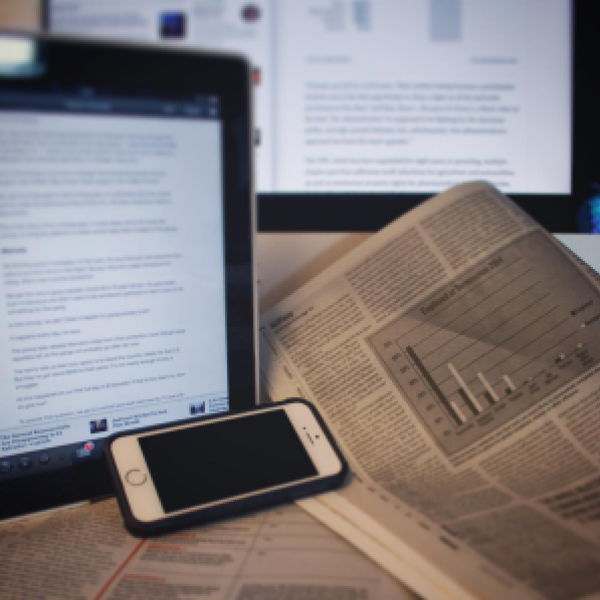 Computer and newspaper on desk