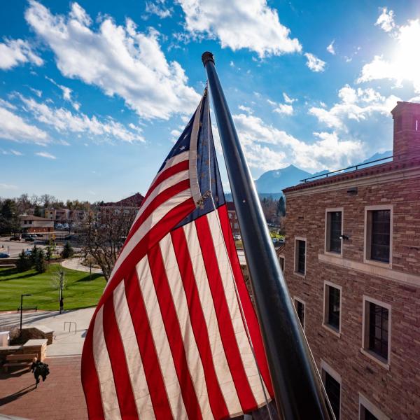 The US flag flies in front of the University Memorial Center. (Photo by Glenn Asakawa/University of Colorado)