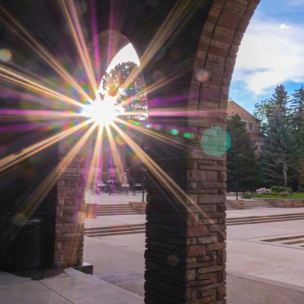 sun peaking through arches on campus