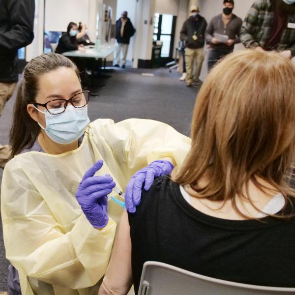 Healthcare worker administers a COVID-19 vaccine during a campus clinic