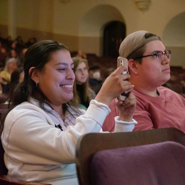 Audience member takes a photo during a Conference on World Affairs session