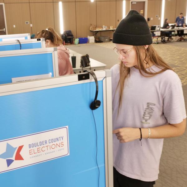 Student voting in a booth on campus