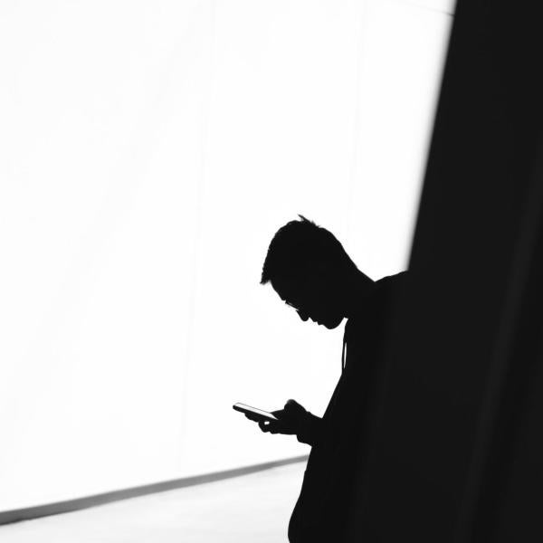 shadowy figure typing on phone