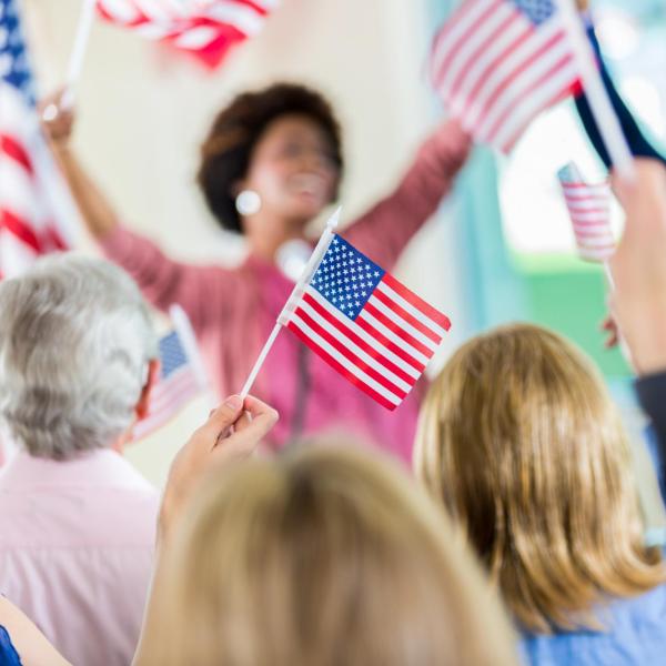 Women wave American flags at an election event