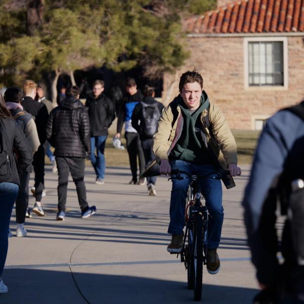 A student rides across campus on the first day of the spring 2020 semester at CU Boulder. (Photo by Glenn Asakawa/University of Colorado)