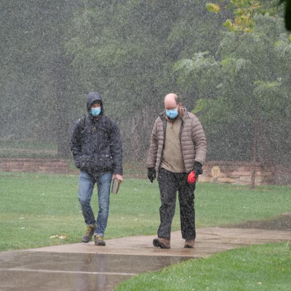 Students walk through the first snow of the fall 2020 semester on the CU Boulder campus. (Photo by Glenn Asakawa/University of Colorado)