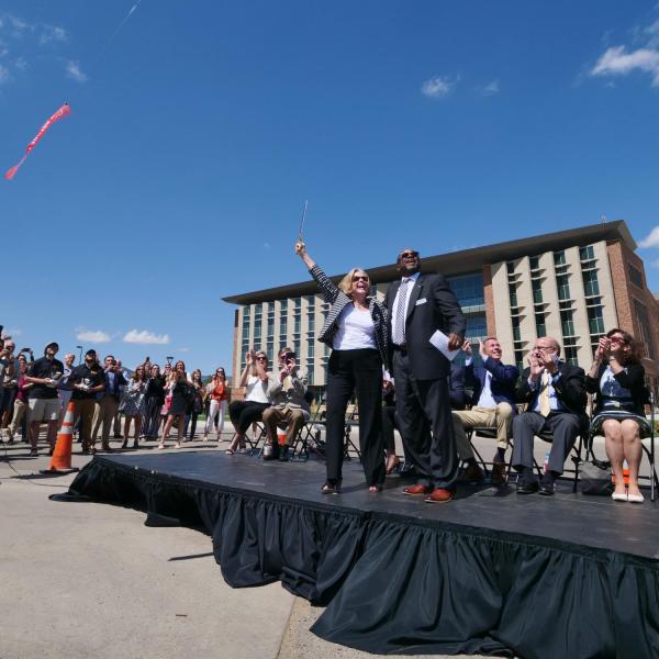 Ann Smead, left, and Brian Argrow, chair of the aerospace engineering department, cut a ribbon held by drones at a ceremony at the new Aerospace Engineering Sciences Building at CU Boulder. (Photo by Glenn Asakawa/CU Boulder)