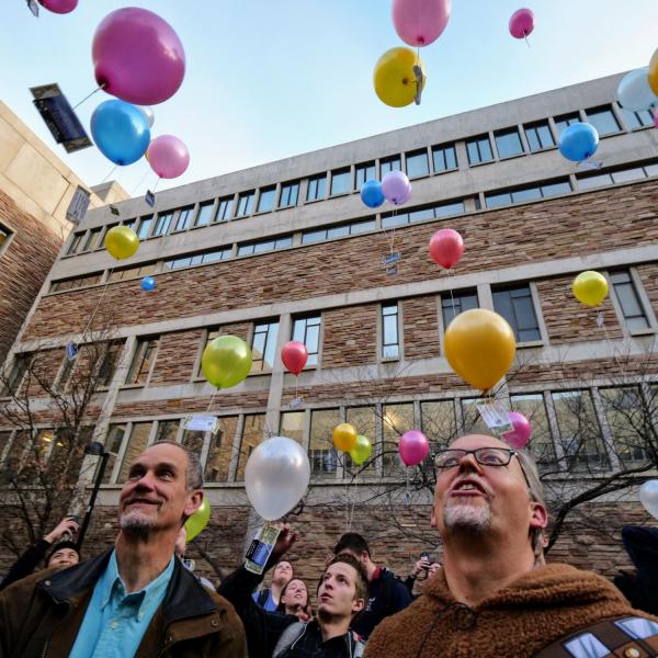 Guest speaker Valerio Ferme and Pathways to Space instructor Chris Koehler watch as students release balloons at the end of their kickoff class. Photo by Glenn Asakawa.