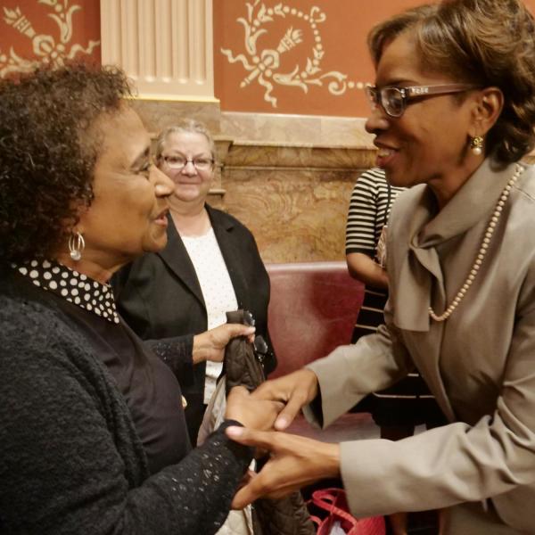 State Senator Rhonda Fields, right, greets CU Professor Polly McLean before providing a tribute of Lucille Buchanan.
