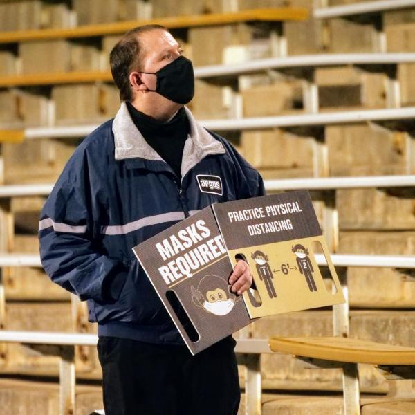 Workers keep safety signs visible to the crowd at the Colorado-UCLA football game on Saturday, Nov. 7, 2020. (Photo by Glenn Asakawa/University of Colorado)