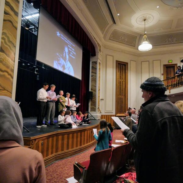 A children's choir ends the MLK Day Celebration by leading the audience with "We Shall Overcome." Photo by Glenn Asakawa.