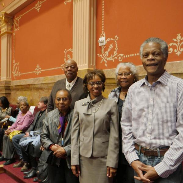 Alphonse Keasley standing at left, poses with State Senator Rhonda Fields, and other friends and genealogists in the senate chamber.
