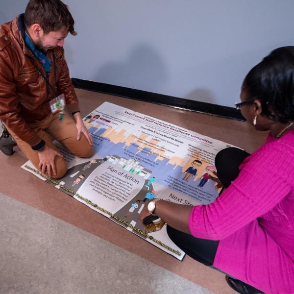 Staff put the finishing touches on a Staff Council-produced poster during the second day of events. Photo by Glenn Asakawa.