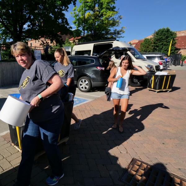 Terri Fiez, Vice Chancellor for Research and Innovation, left, helps students move-in on Tuesday, Aug. 20, 2019, at Baker Hall. (Photo by Glenn Asakawa/University of Colorado)