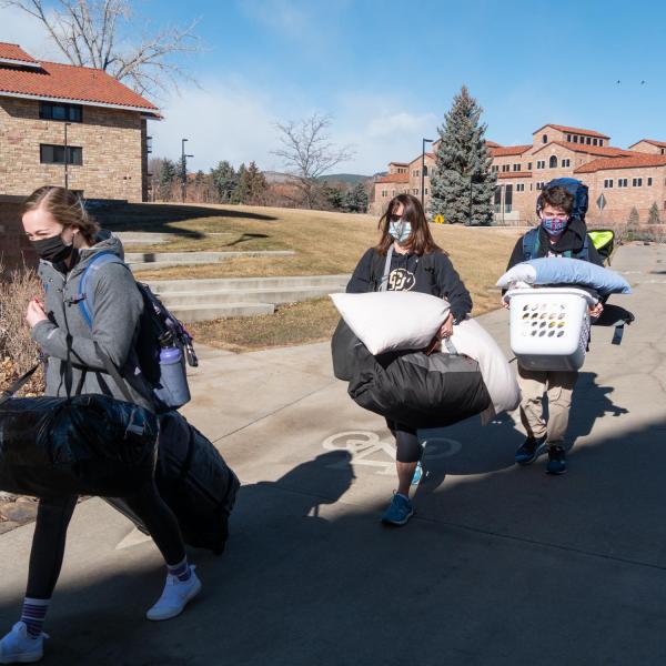 CU Boulder first year engineering students Isabell Young, left, and Michael Shockley, right, get help moving in from Shockley’s mom, Kathy, center, at the Kittredge complex on Feb. 7, 2021. (Photo by Glenn Asakawa/University of Colorado)