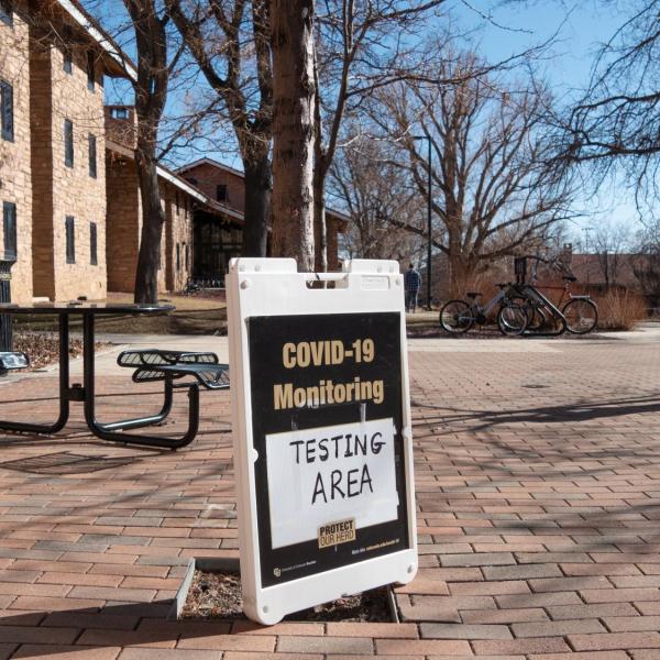 A COVID-19 monitoring station and signage near Kittredge Center on the CU Boulder campus. (Photo by Glenn Asakawa/University of Colorado)
