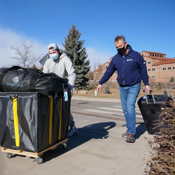 CU Boulder first year student Jack Archibald of Massachusetts, left, gets help from his dad Gavin as he returns to the Kittredge Central residence hall on Feb. 7, 2021. (Photo by Glenn Asakawa/University of Colorado)