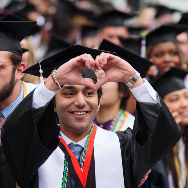 Graduate looks up at friends and family in the stands