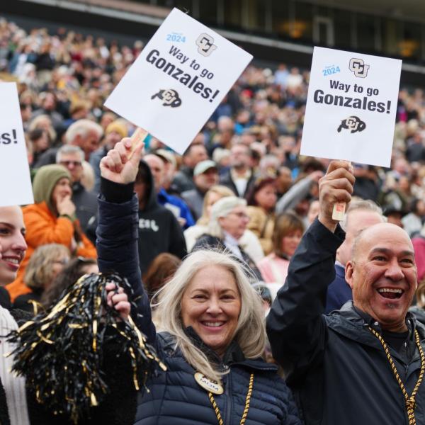 Family and friends cheer for graduates as the enter Folsom Field