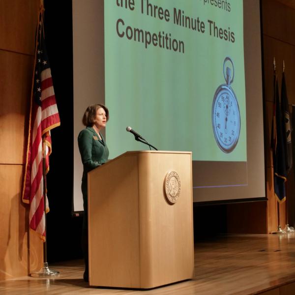 Ann Schmiesing welcomes the audience to the Three Minute Thesis Competition. Photo by Casey A. Cass.