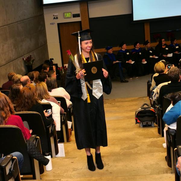 Graduate poses for photo after Integrative Physiology recognition ceremony
