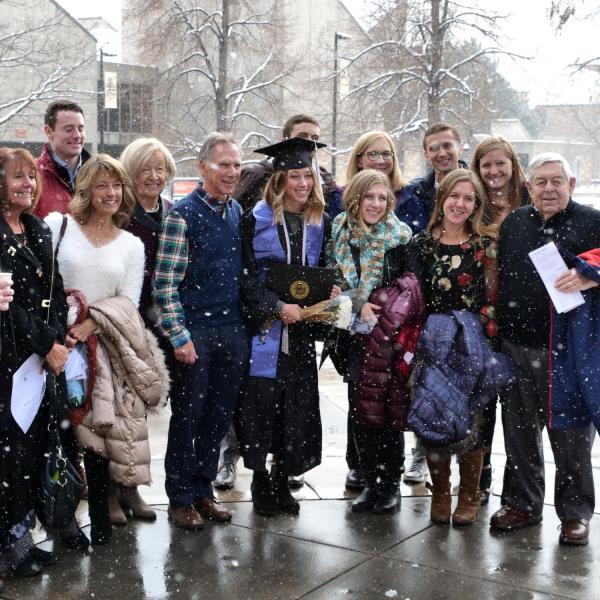 Graduate poses with family for photo after Integrative Physiology recognition ceremony