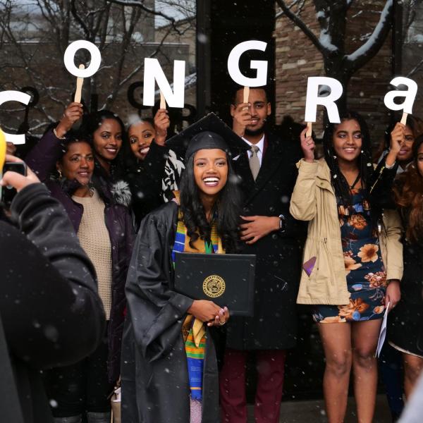 Graduate poses with family for photo after Integrative Physiology recognition ceremony