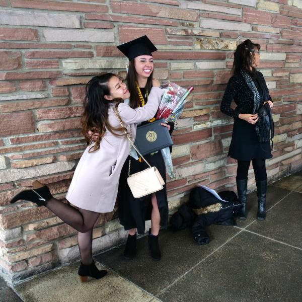 Graduate poses with family for photo after Integrative Physiology recognition ceremony