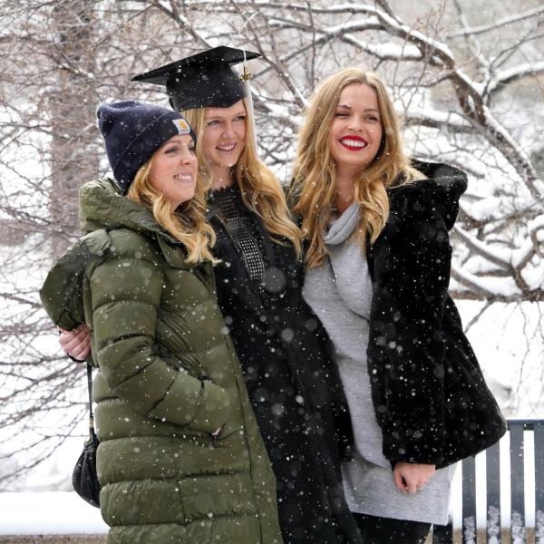 Graduate poses with family for photo after Integrative Physiology recognition ceremony