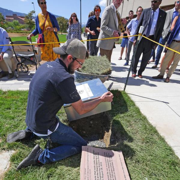 An aerospace engineering employee prepares to bury a time capsule.