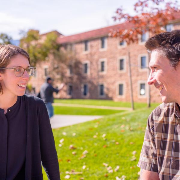 Two friends chat as the autumn sunshine warms campus grounds. Photo by Patrick Wine.