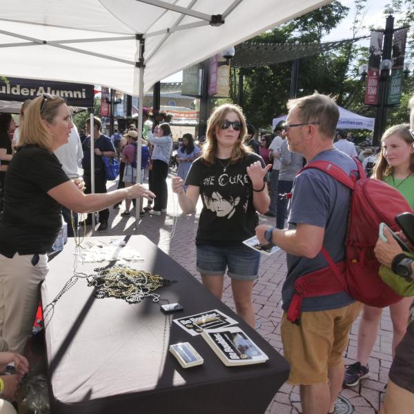 Volunteers speak with visitors at a CU table on Pearl Street