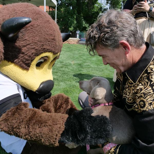 Chief Operating Officer Patrick O'Rourke lets Chip pet his puppy at Buffs Back Together.