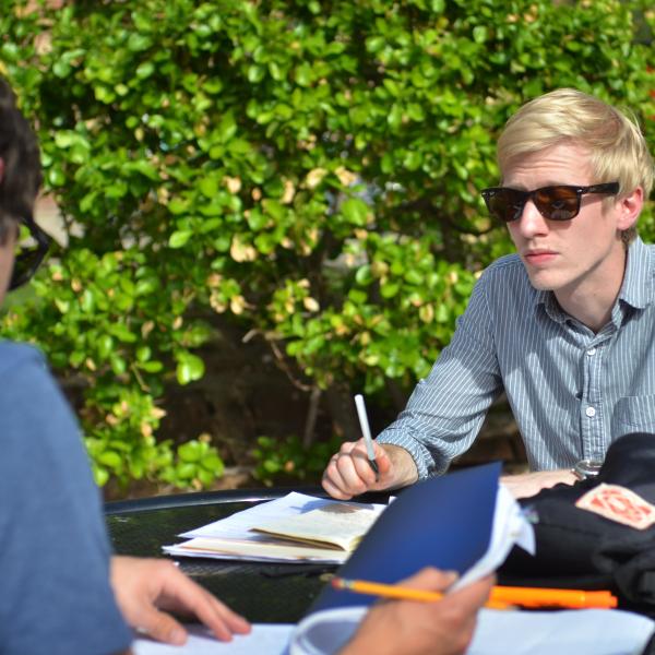 Students study at table outdoors