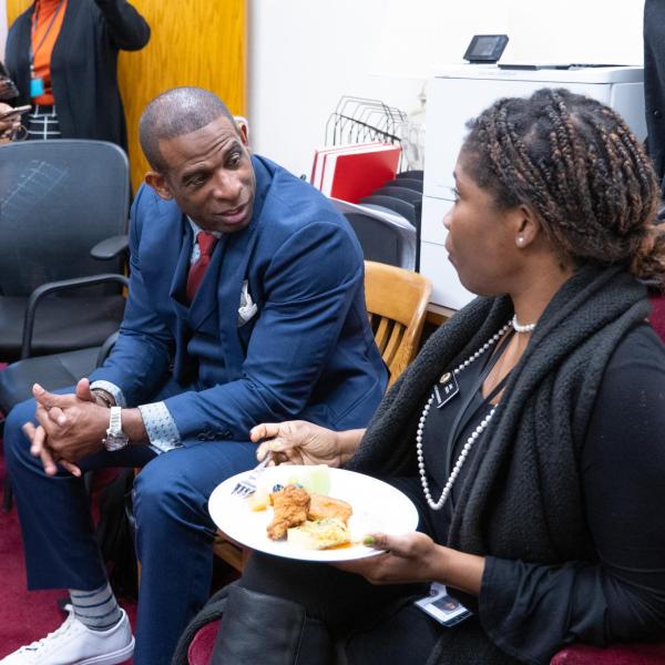 Deion Sanders talks with Rep. Junie Joseph, a CU Law alumna, as he joins Colorado Black Caucus lawmakers for breakfast.