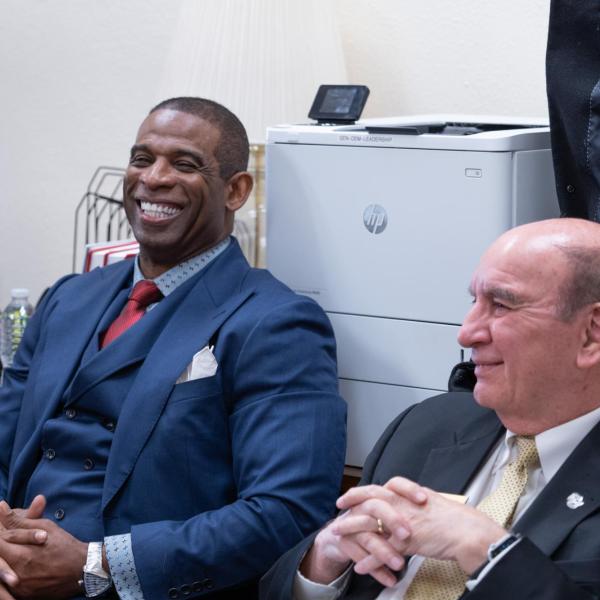 Deion Sanders and Chancellor Phil DiStefano sit and listen during a breakfast meeting of the Colorado Black Caucus lawmakers