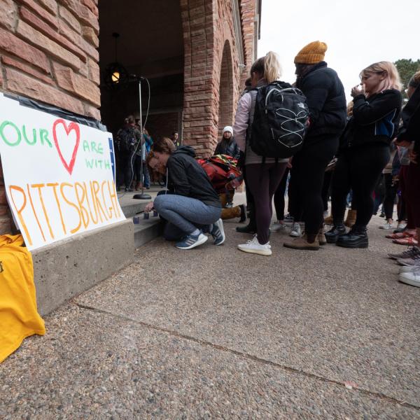 Students, faculty and staff line up to light candles in honor of those killed and to show solidarity of support against anti-semitism. Photo by Glenn Asakawa.