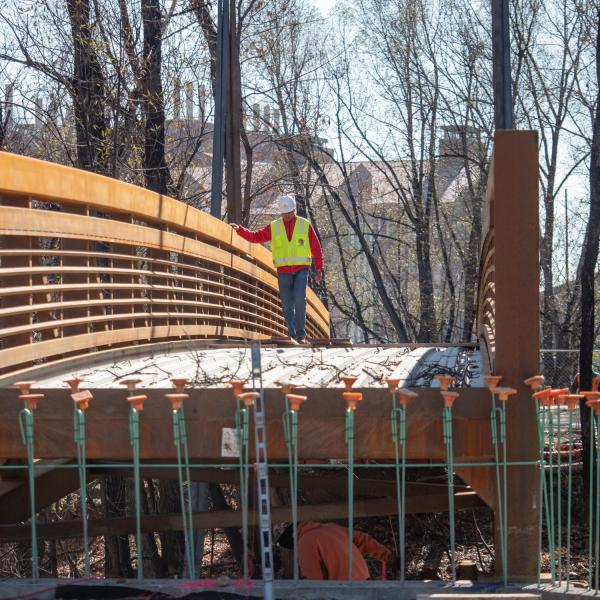 Workers use a mobile crane to place a 33-ton bridge over Boulder Creek on East Campus. Photo by Glenn Asakawa.