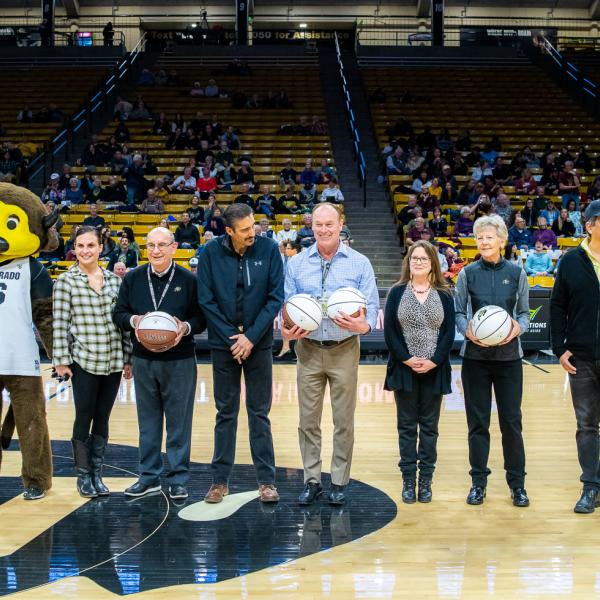 The four 2019 Chancellor’s Employee of the Year winners were honored during halftime of a recent Colorado basketball game. Left to right in this photo are: Chip the Buffalo, Jessie Kasynski, Chancellor Phillip DiStefano, J. Javier Portillo, Athletic Director Rick George, Melynda Slaughter, Ceal Barry and Alex Viggio. (Photo by Patrick Wine/University of Colorado)