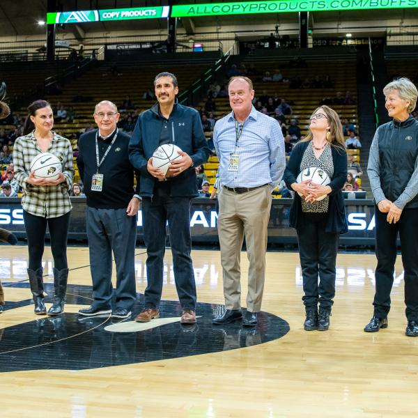 The four 2019 Chancellor’s Employee of the Year winners were honored during halftime of a recent Colorado basketball game. Left to right in this photo are: Chip the Buffalo, Jessie Kasynski, Chancellor Phillip DiStefano, J. Javier Portillo, Athletic Director Rick George, Melynda Slaughter, Ceal Barry and Alex Viggio. (Photo by Patrick Wine/University of Colorado)
