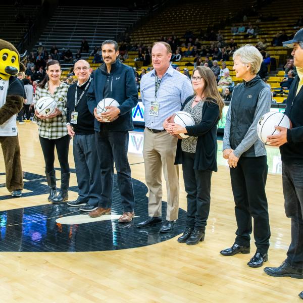 The four 2019 Chancellor’s Employee of the Year winners were honored during halftime of a recent Colorado basketball game. Left to right in this photo are: Chip the Buffalo, Jessie Kasynski, Chancellor Phillip DiStefano, J. Javier Portillo, Athletic Director Rick George, Melynda Slaughter, Ceal Barry and Alex Viggio. (Photo by Patrick Wine/University of Colorado)