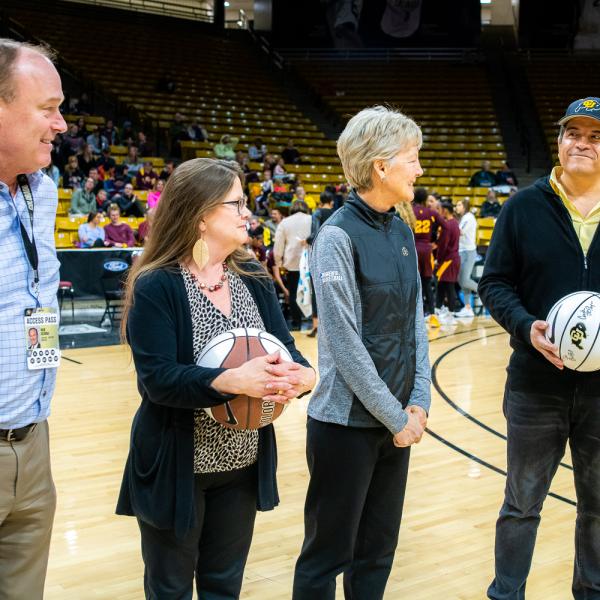 The four 2019 Chancellor’s Employee of the Year winners were honored during halftime of a recent Colorado basketball game. Left to right in this photo are: Athletic Director Rick George, Melynda Slaughter, Ceal Barry and Alex Viggio. (Photo by Patrick Wine/University of Colorado)