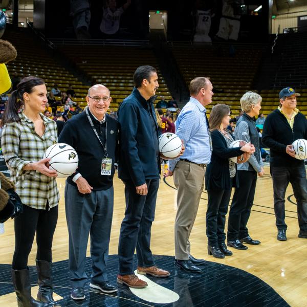 The four 2019 Chancellor’s Employee of the Year winners were honored during halftime of a recent Colorado basketball game. Left to right in this photo are: Chip the Buffalo, Jessie Kasynski, Chancellor Phillip DiStefano, J. Javier Portillo, Athletic Director Rick George, Melynda Slaughter, Ceal Barry and Alex Viggio. (Photo by Patrick Wine/University of Colorado)